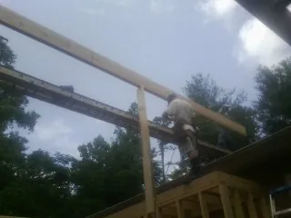 Carpenter setting a ridge beam over a new addition frame — Ice Dam Removal by Roofing Brothers in Bethune